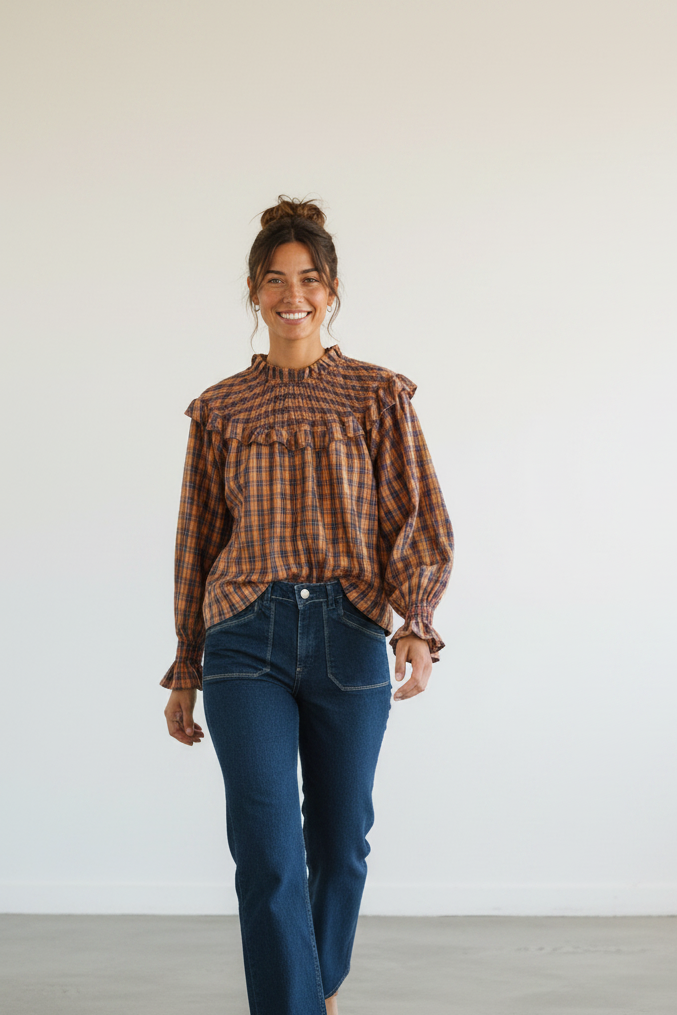 Calendula-shop Albania long-sleeve plaid blouse with ruffled chest and cuffs worn by a smiling woman with jeans