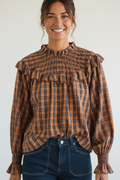 Calendula-shop Albania long-sleeve blouse in brown plaid with ruffled neck, chest ruffle, and smocked cuffs.