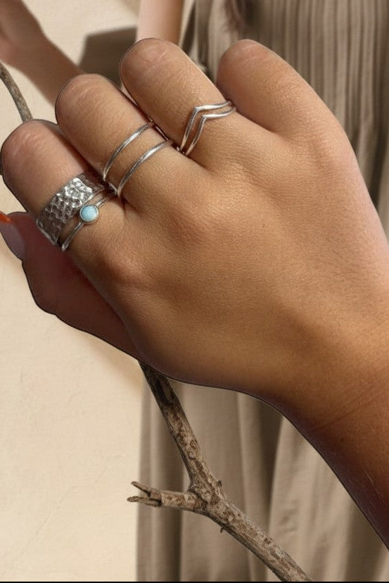 Anillo doble de plata de ley 925 de Calendula-shop, diseño abierto y minimalista lucido en la mano de una mujer.