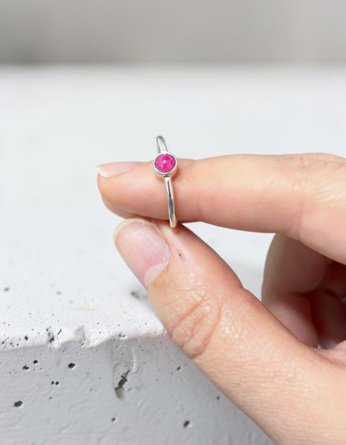 Anillo fino de plata de ley 925 con piedra natural de ágata fucsia de Calendula-shop sostenido entre los dedos