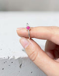 Anillo fino de plata de ley 925 con piedra natural de ágata fucsia de Calendula-shop sostenido entre los dedos