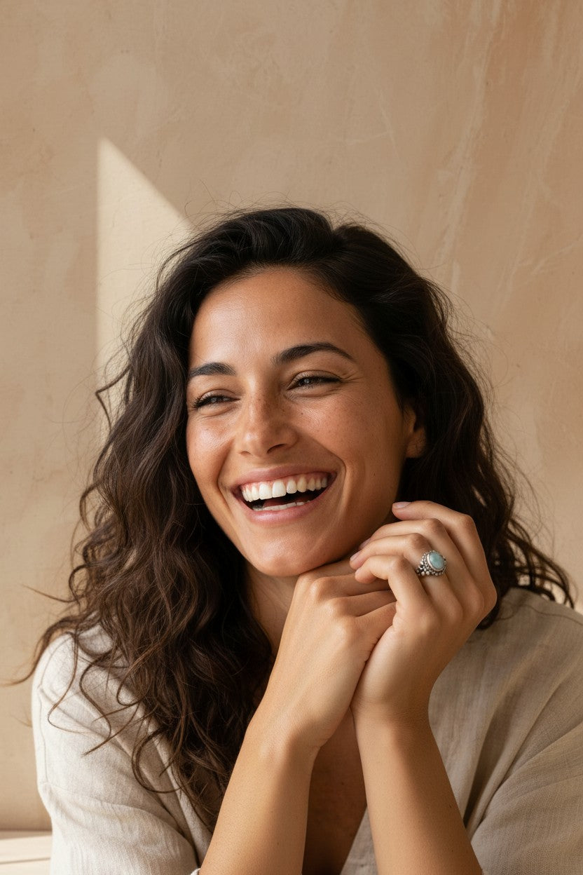 Mujer sonriente luciendo un anillo de plata de ley 925 con piedra aguamarina de Calendula-shop