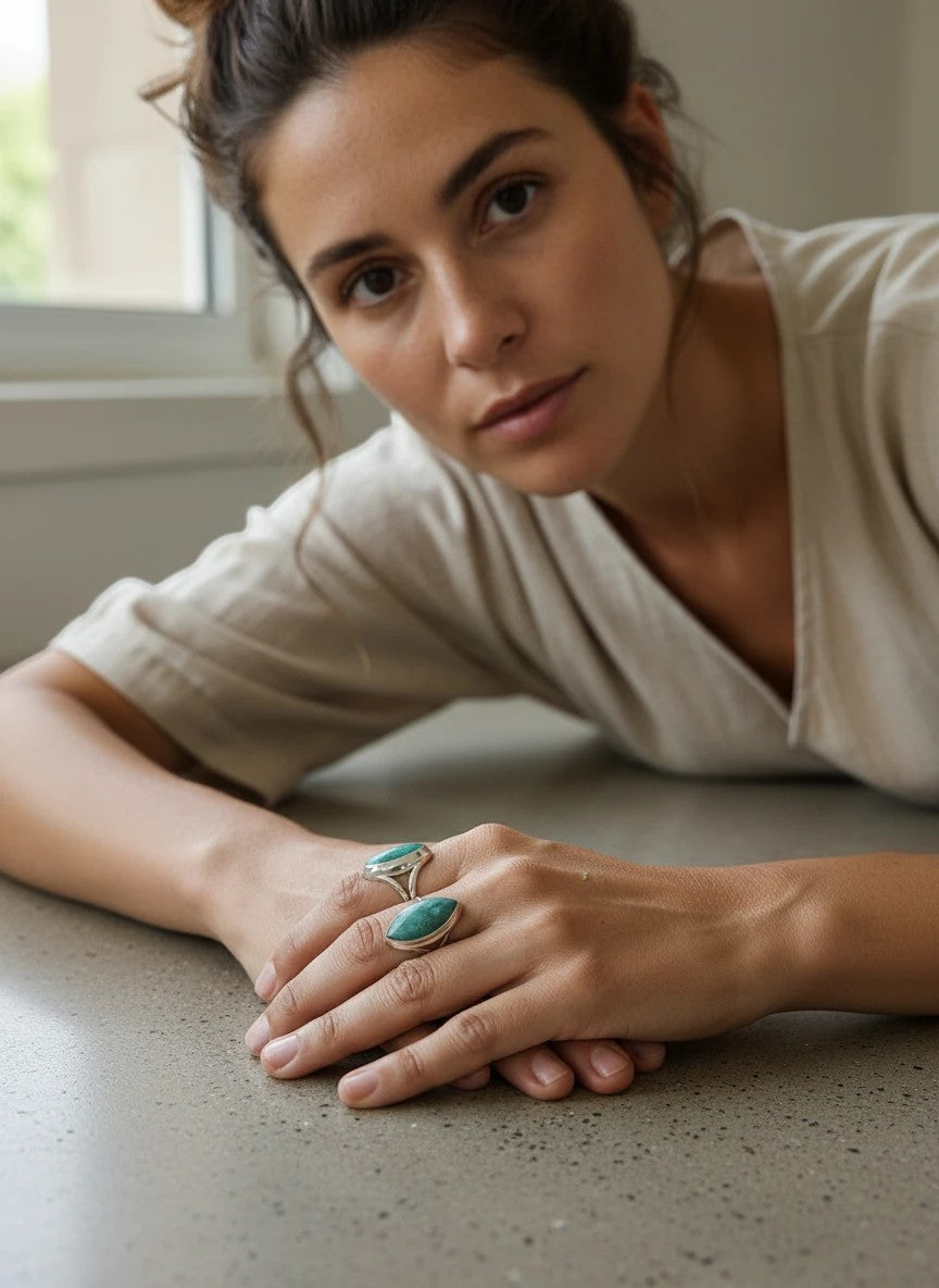 Modelo luciendo anillos de plata de ley 925 con esmeralda natural de Calendula-shop en un diseño abombado