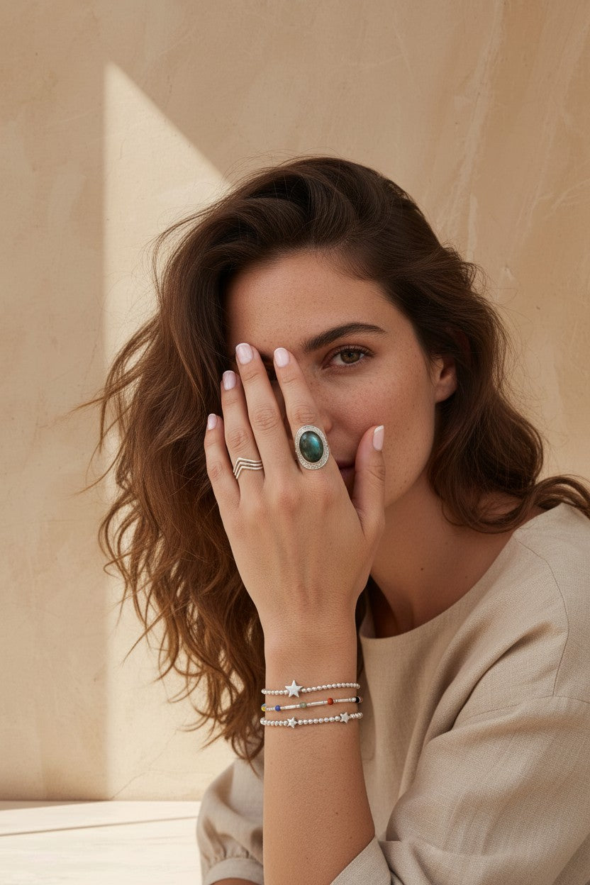 Anillo ancho Calendula-shop de plata 925 con piedra natural de labradorita y diseño étnico en la mano de una modelo