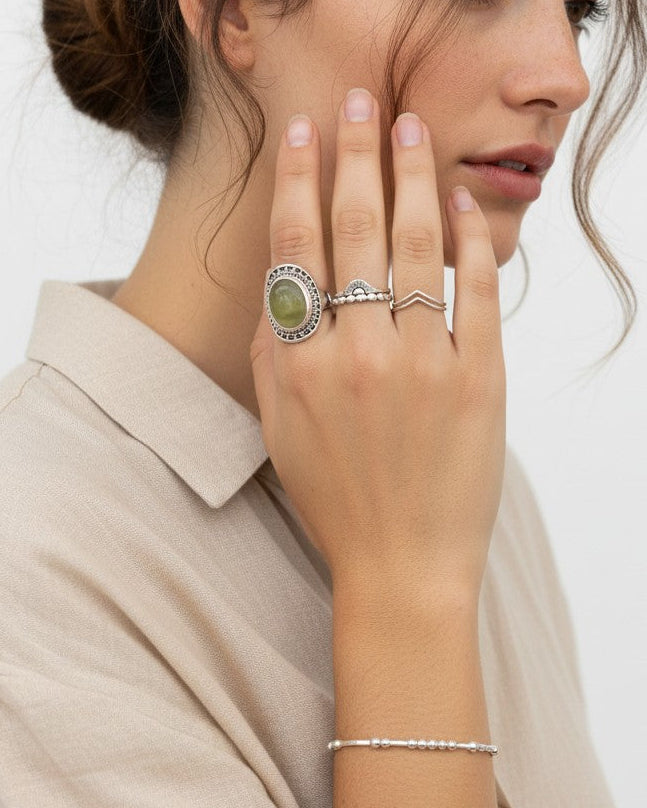 Anillo ancho de plata de ley 925 con piedra natural de prehnita verde de Calendula-shop en la mano de una modelo