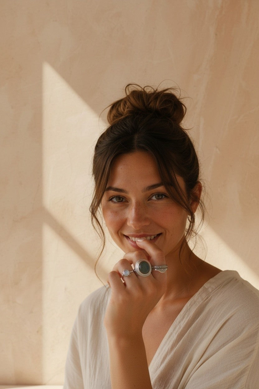 Mujer sonriente luciendo el anillo Sol Naciente de plata de ley 925 de Calendula-shop con diseño de rayos solares