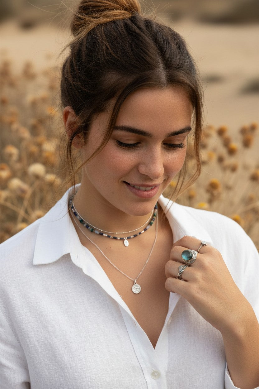 Mujer luciendo el anillo Sol Naciente de plata de ley de Calendula-shop con diseño elegante en un entorno natural