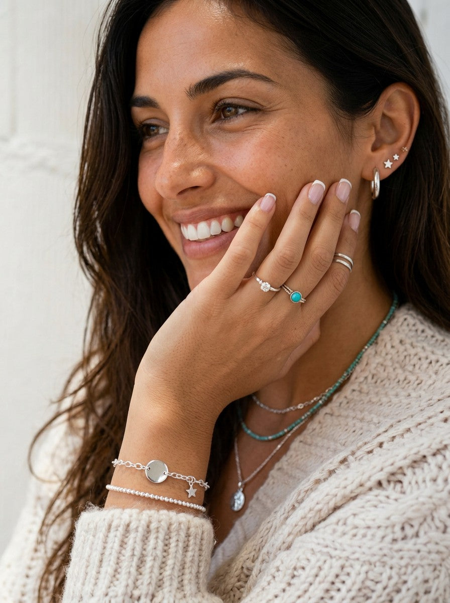 Mujer sonriente luciendo aros Adigio de plata de ley 925 de Calendula-shop, pendientes lisos de 18 mm con cierre.
