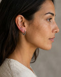 Aros étnicos Andry de Calendula-shop en plata de ley 925 con diseño labrado tipo sol, puestos en una modelo.
