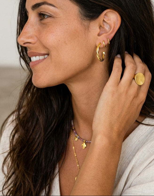 Modelo luciendo pendientes de aro rizado AROS MOON ORO de Calendula-shop en plata de ley 925 bañada en oro.