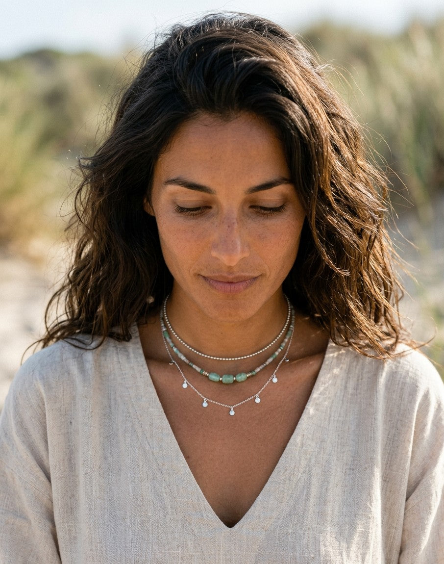 Modelo con choker de bolitas de plata de ley 925 de Calendula-shop, combinado con otros collares en un entorno natural.