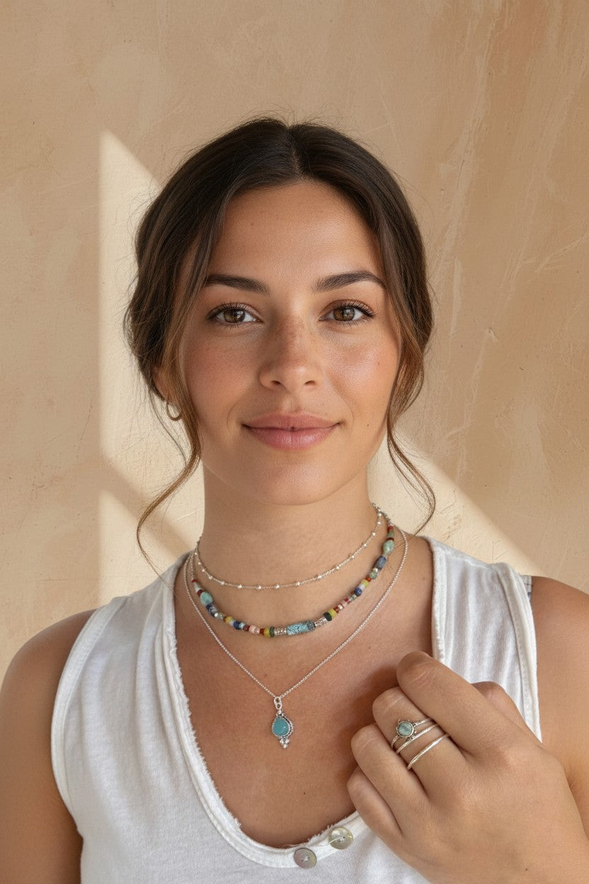 Mujer luciendo el colgante Eter de Calendula-shop con piedra de calcedonia azul y cadena de plata fina