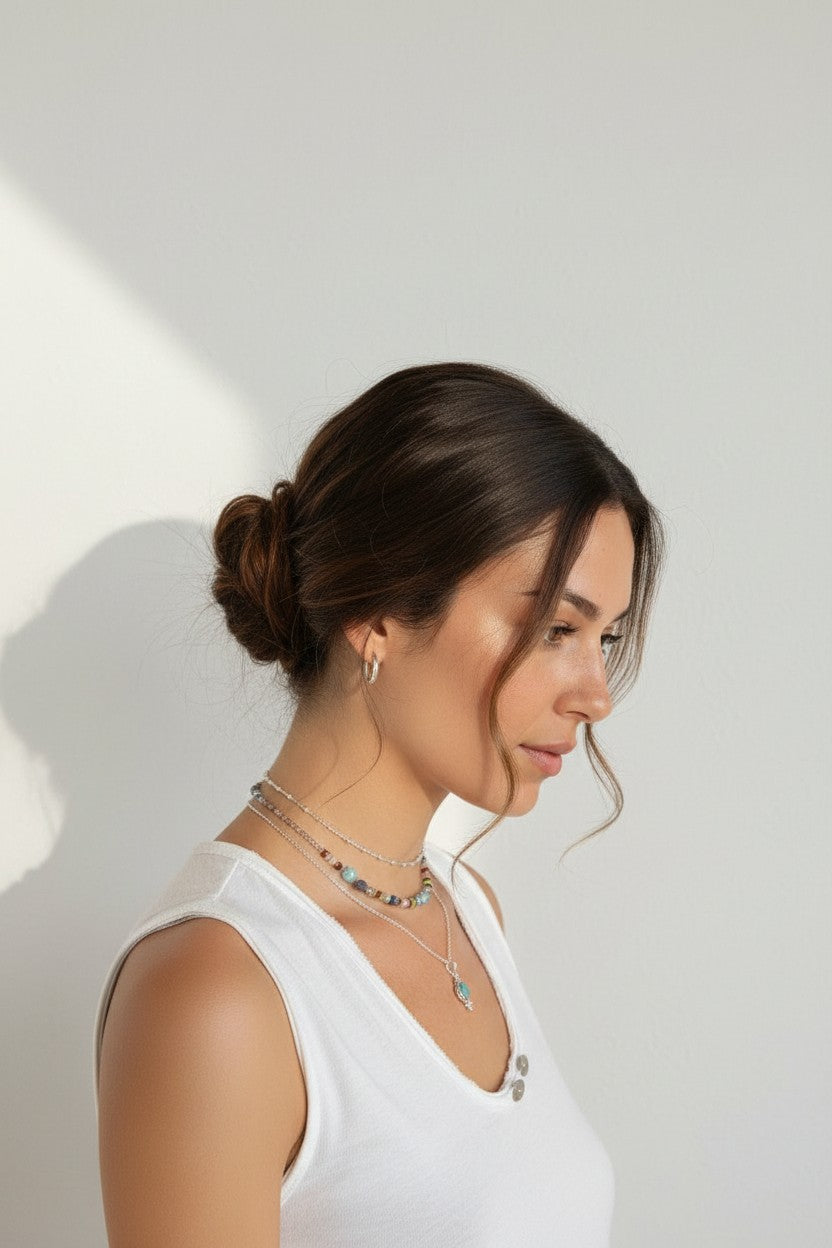 Colgante Eter de Calendula-shop con piedra natural de calcedonia azul y cadena de plata fina en el cuello de una mujer