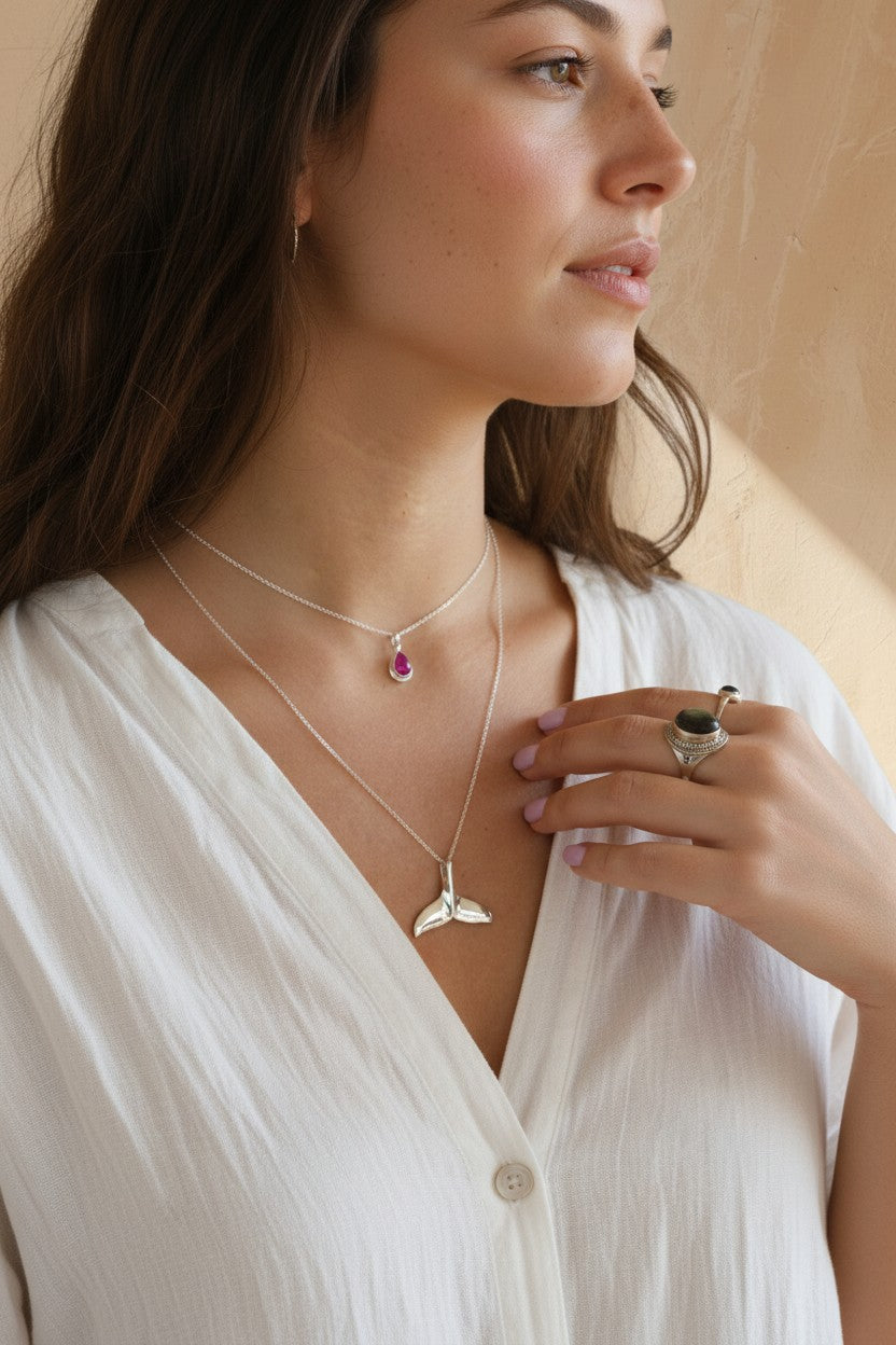 Colgante Cosmos de Calendula-shop con ágata fucsia en plata de ley, lucido por una mujer con cadena fina