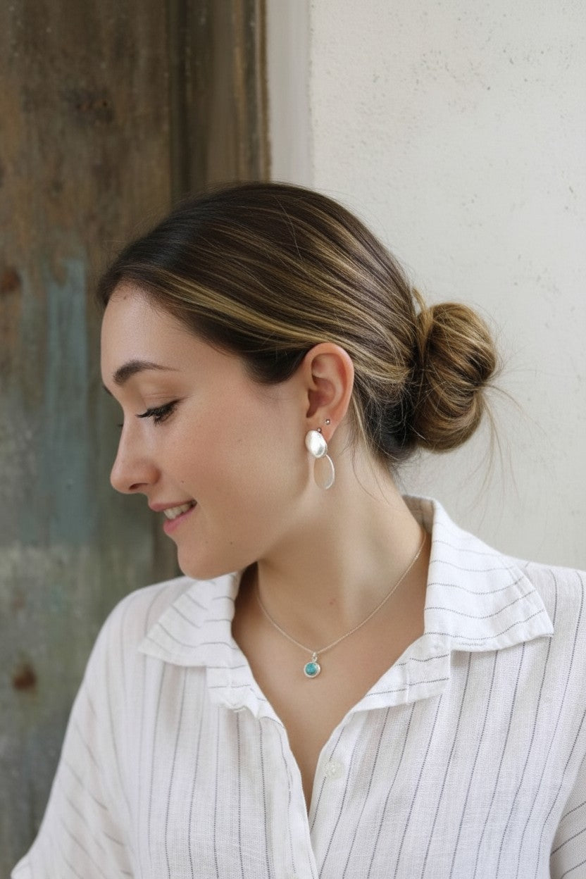 Mujer con colgante Cosmos de Calendula-shop en plata de ley con piedra ágata fucsia y pendientes a juego