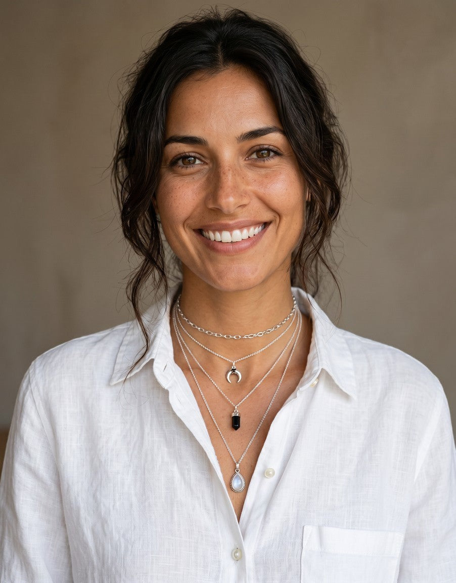 Mujer sonriente luciendo colgante péndulo de piedra natural y plata de ley de Calendula-shop con cadena fina
