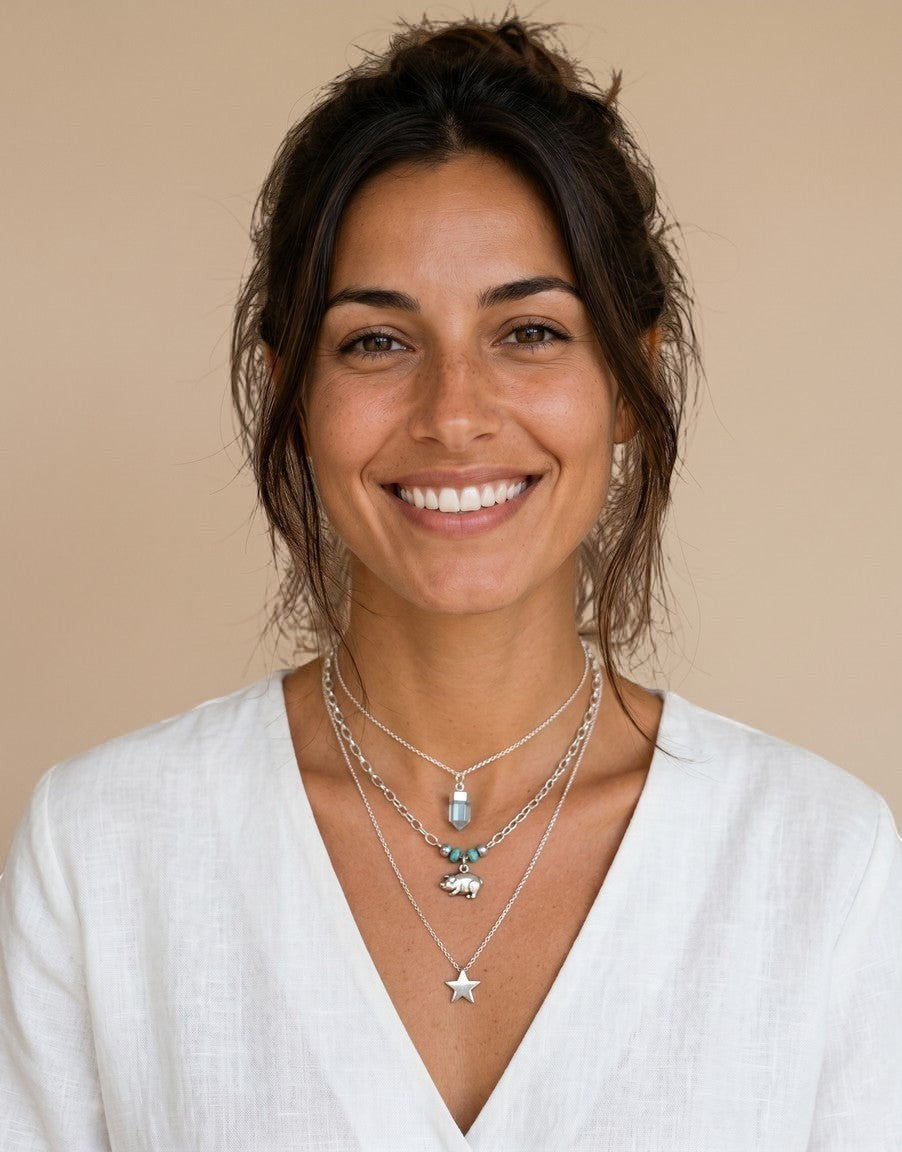 Mujer sonriente luciendo collares de plata de ley con colgante de péndulo de piedra natural de Calendula-shop
