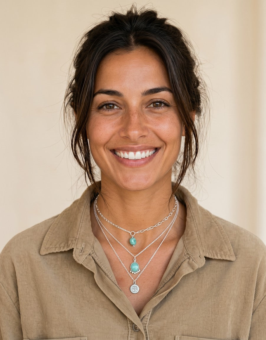 Mujer sonriente luciendo colgante Calendula-shop de plata de ley con piedra natural amazonita y detalles de bolitas