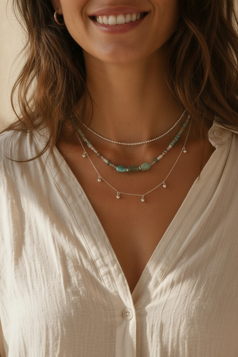 Colgante cascada bolitas de plata de ley de Calendula-shop lucido por una mujer con camisa blanca