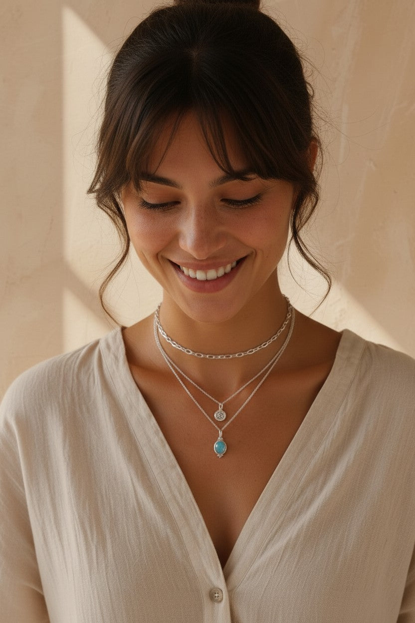 Colgante Fluye de Calendula-shop en plata de ley con piedra calcedonia celeste en el cuello de una modelo sonriente
