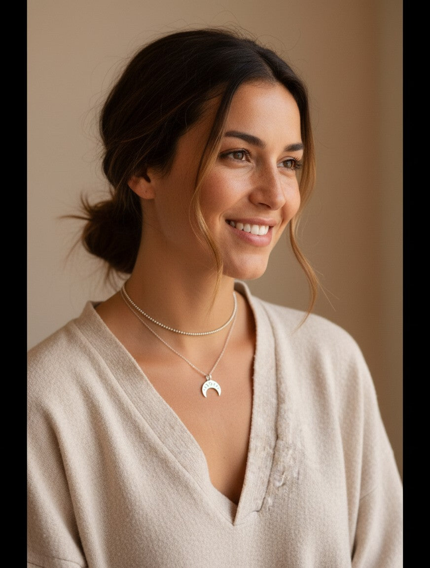 Mujer luciendo un colgante de plata Calendula-shop con diseño de fases lunares y estilo étnico en su cuello.