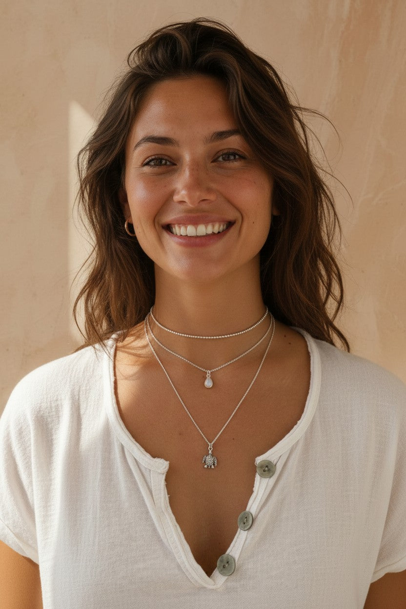 Mujer sonriente luciendo un colgante de tortuga de plata de ley de Calendula-shop con cadena fina