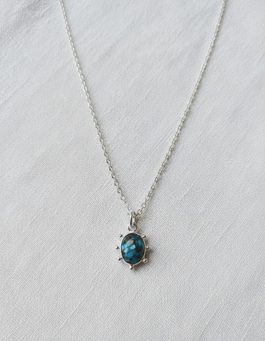 Colgante Perseo de Calendula-shop con piedra turquesa natural y cadena de plata de ley en fondo blanco
