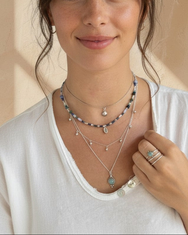Modelo luciendo el colgante Venus de calcedonia y plata de ley de Calendula-shop con capas de collares finos