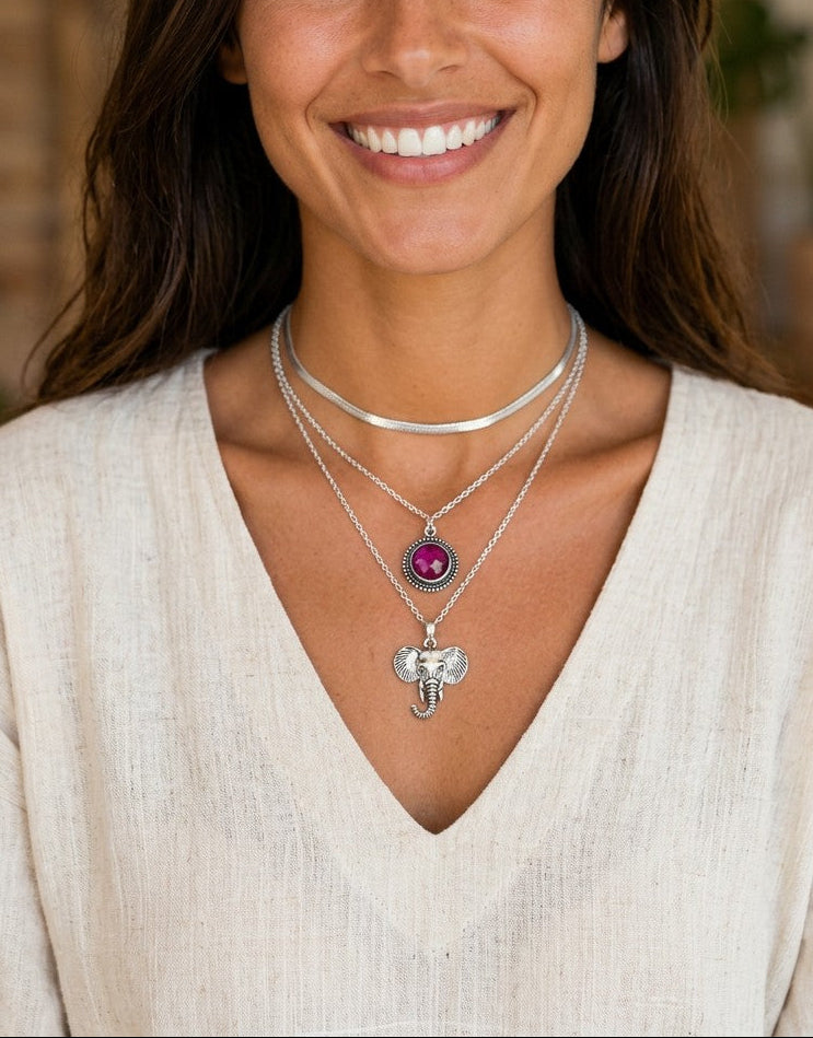 Modelo sonriente luciendo collar de elefante estilo boho de Calendula-shop en plata de ley 925 con colgante circular.