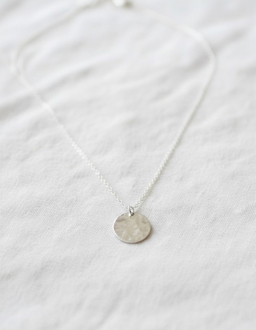 Collar Calendula-shop de plata de ley con colgante redondo troquelado que simula una luna llena sobre fondo blanco