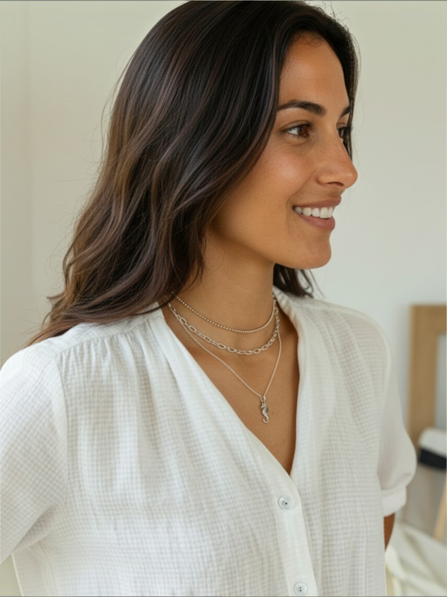 Modelo luciendo el collar Ocean de Calendula-shop, una cadena de plata de ley con colgante de caballito de mar.