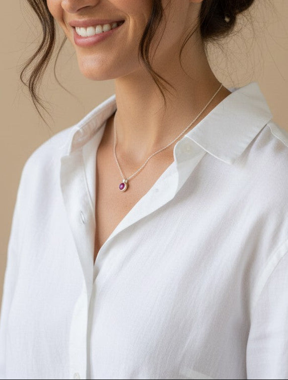 Modelo sonriente luciendo un collar Calendula-shop de plata de ley con colgante de piedra natural fucsia