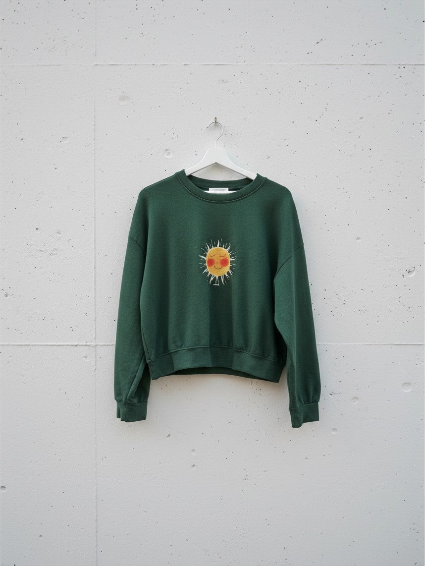 Calendula-shop green cropped sweatshirt with a cute sun illustration on the chest, made of cotton and elastane.