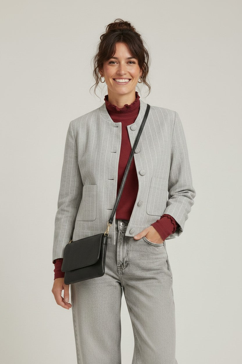 Calendula-shop cropped grey pinstriped jacket with button front, worn by a smiling woman with a crossbody bag.