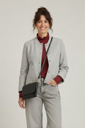 Calendula-shop cropped grey pinstriped jacket with button front, worn by a smiling woman with a crossbody bag.