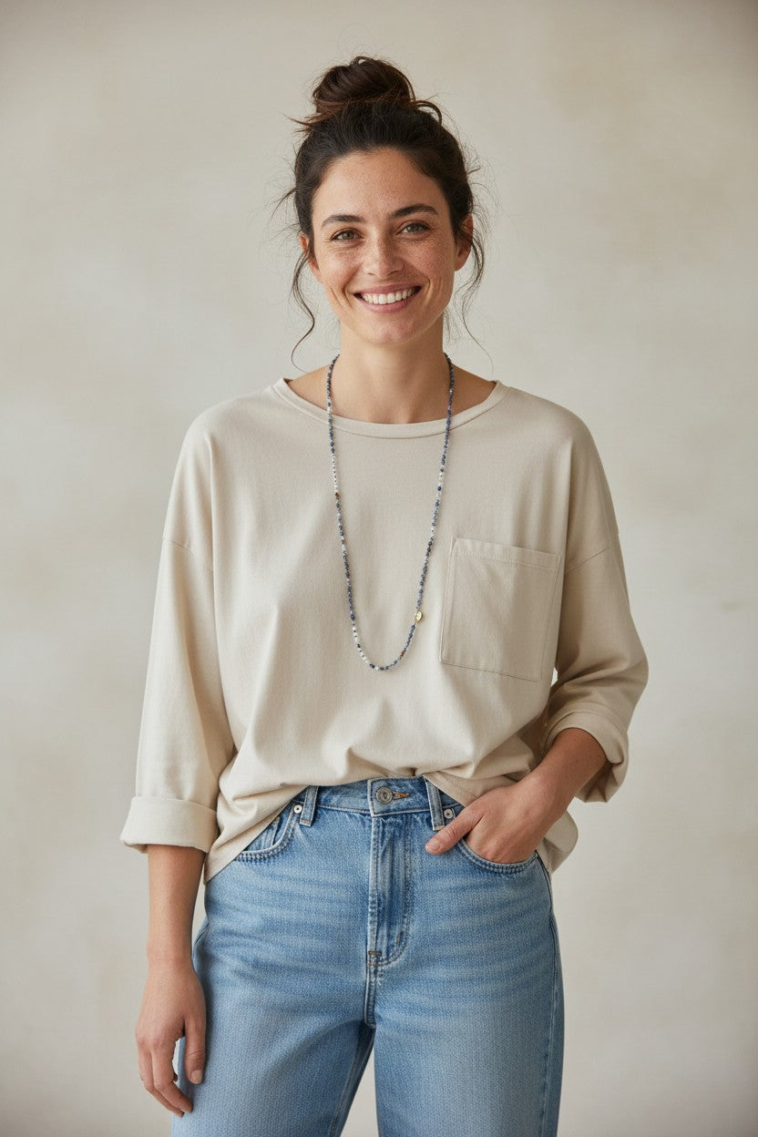Calendula-shop Marta long-sleeve beige cotton t-shirt with chest pocket worn by a smiling woman
