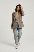 Calendula-shop oversized plaid blazer in brown tones worn by a smiling woman with jeans and a beige sweater