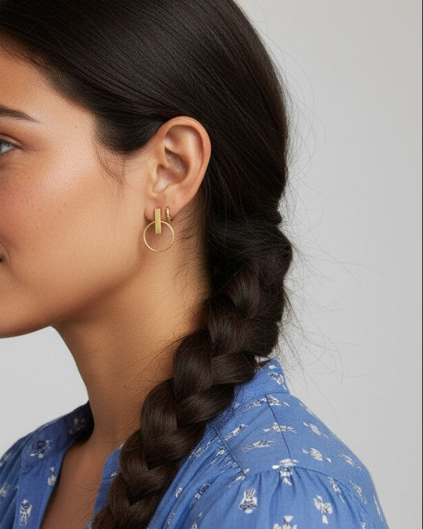 Pendientes Calendula-shop de plata bañada en oro con diseño de barra y aro, lucidos por una modelo de perfil.