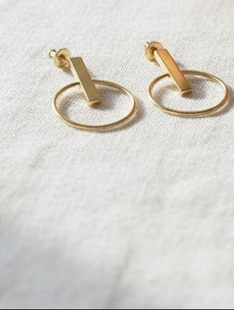 Pendientes Calendula-shop de plata con baño de oro, diseño de barrita y aro circular de 15mm en manos