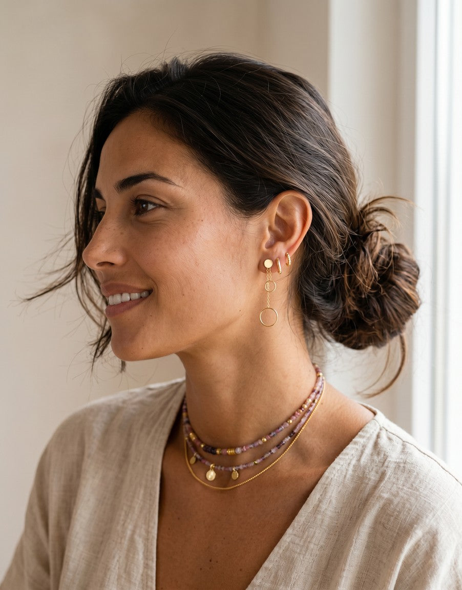 Pendientes largos Calendula-shop de plata bañada en oro con dos círculos colgantes en una modelo de perfil