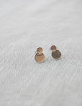 Pendientes Mimosa de Calendula-shop en plata de ley 925 con diseño de dos círculos superpuestos sobre fondo textil
