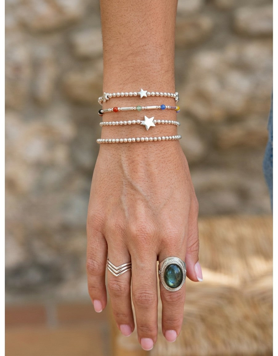 Pulsera Arcoiris de plata de ley 925 de Calendula-shop con bolitas de colores y abalorios en muñeca femenina.
