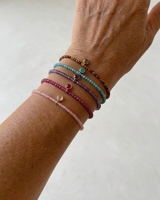 Pulseras Calendula-shop de plata bañada en oro con bolitas de piedras naturales coloridas en una muñeca