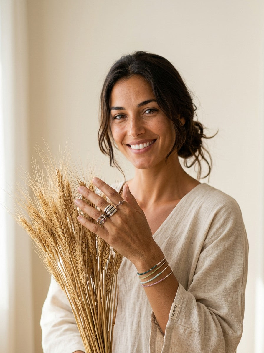 Mujer sonriente con pulseras Mikonos de Calendula-shop hechas a mano en plata 925 con piedras naturales y bolitas