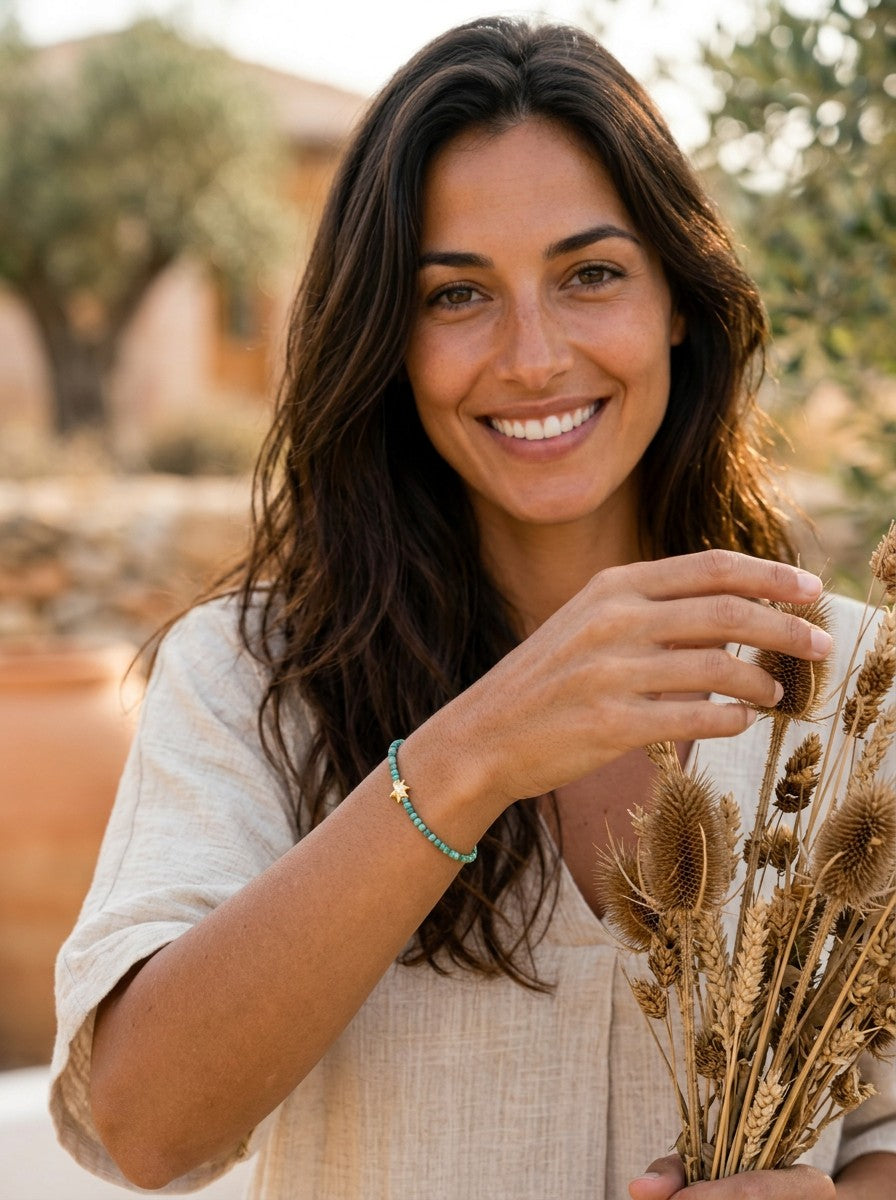 Pulsera Salitre de Calendula-shop con piedras naturales turquesas y detalle de estrella dorada en mujer sonriente.