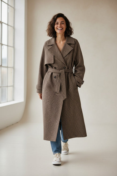 Calendula-shop Sofia oversize brown wool-blend trench coat worn by a smiling woman with jeans and sneakers