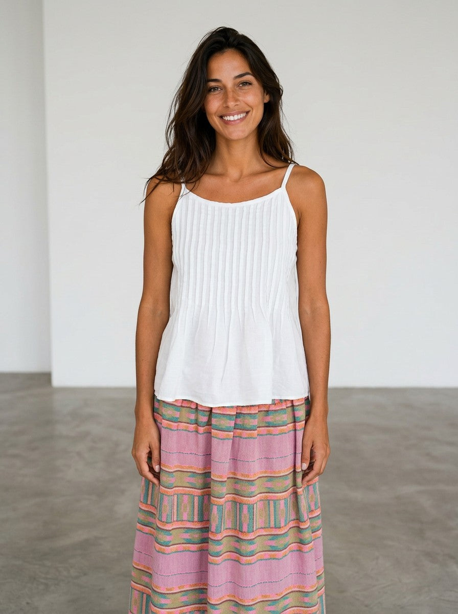 Modelo sonriente con top blanco Calendula-shop de tirantes y jaretas, estilo casual y ligero en viscosa.