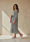 Modelo con vestido Calendula-shop María azul de viscosa, corte amplio, mangas abullonadas y estampado geométrico.