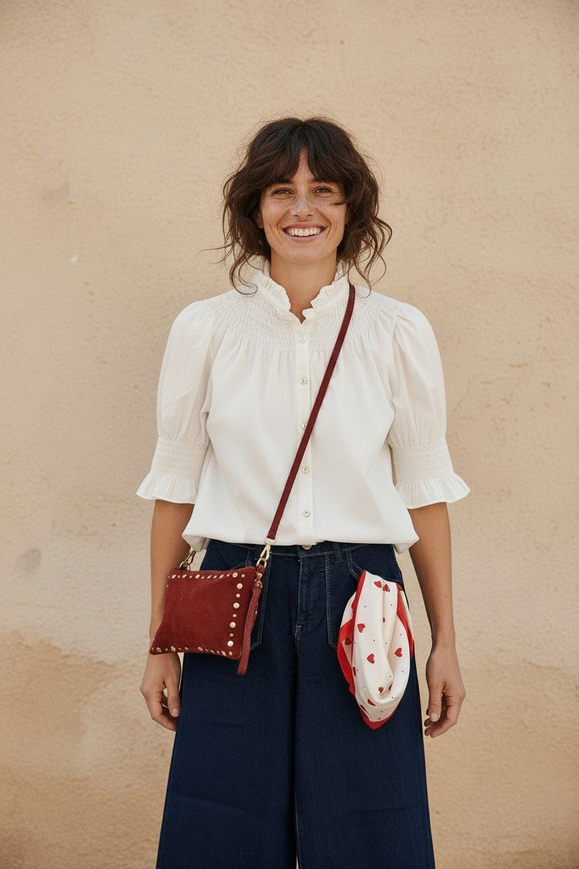 Calendula-shop white short-sleeve blouse with a ruffled collar and smocked details worn by a smiling woman