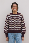Modelo con jersey Iris granat, moño bajo y sonrisa amplia